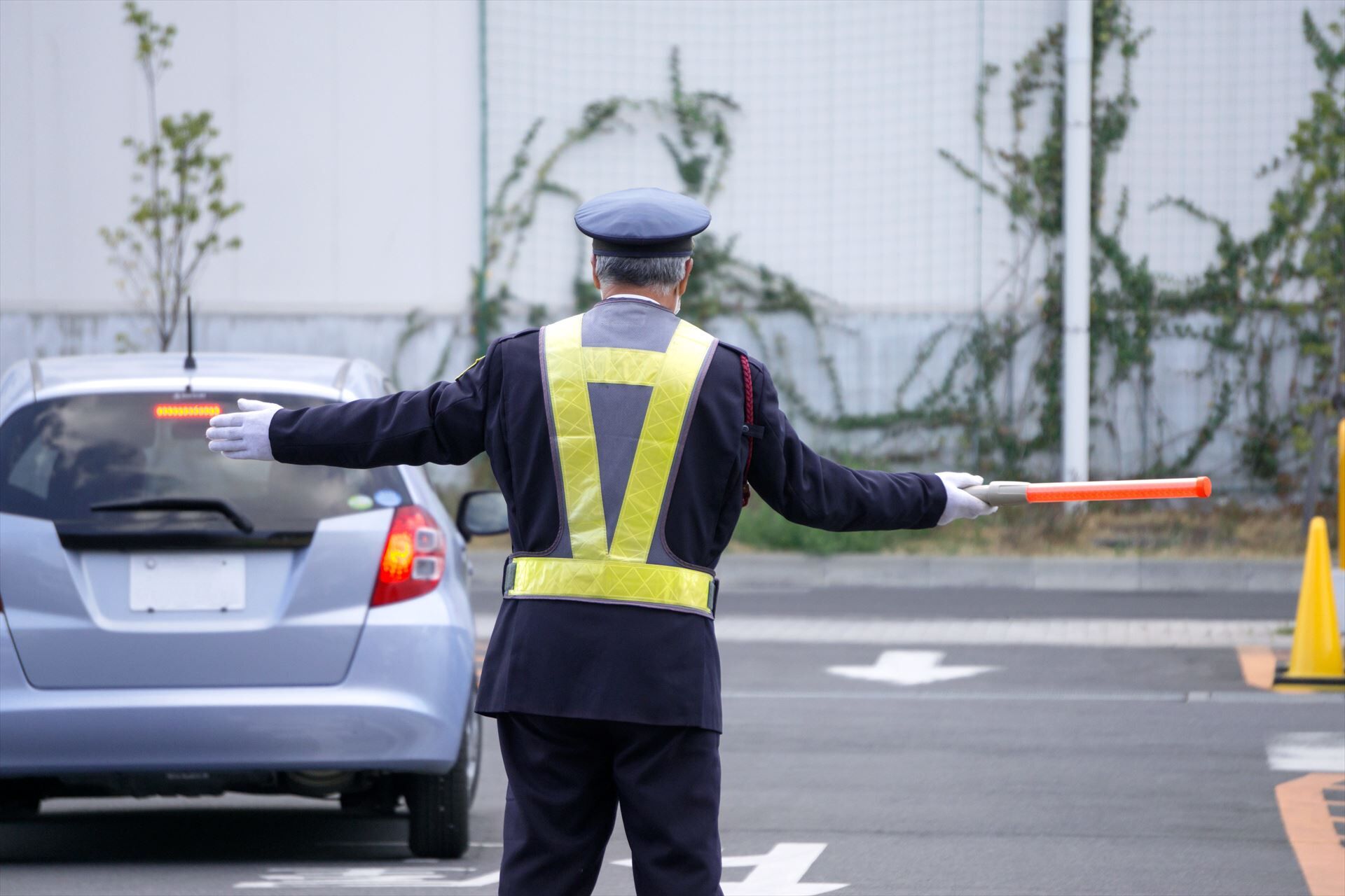 駐車場で交通誘導する警備員